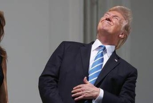 Trump, faccia a faccia con l'eclissi: occhi puntati al sole e niente occhiali Trump, faccia a faccia con l'eclissi: occhi puntati al sole e niente occhiali